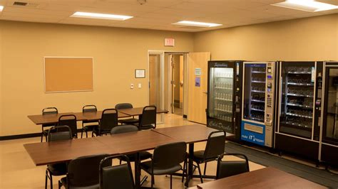 Clean meeting or board room with tables, chairs, and vending machines